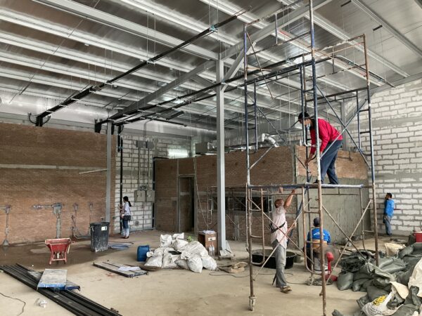 Workers on scaffolding at an interior construction site