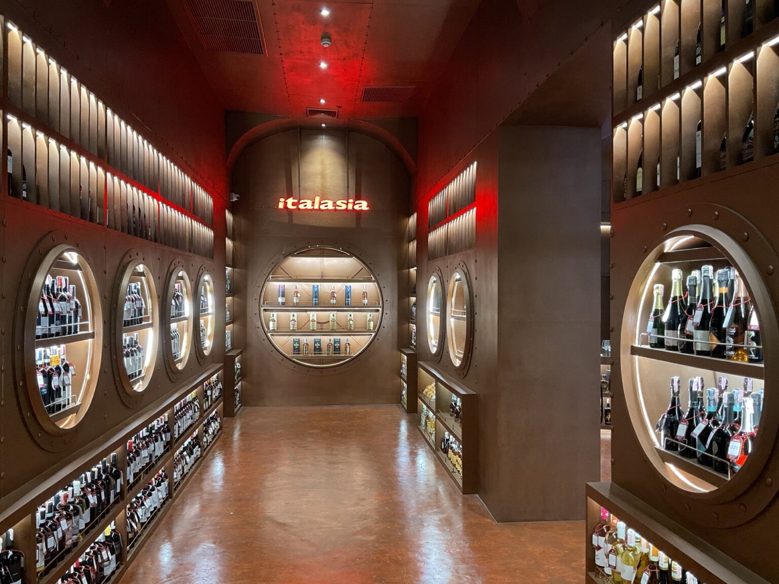 A renovated 'italasia' wine store with an extensive display of wine bottles lined up on well-organized shelves