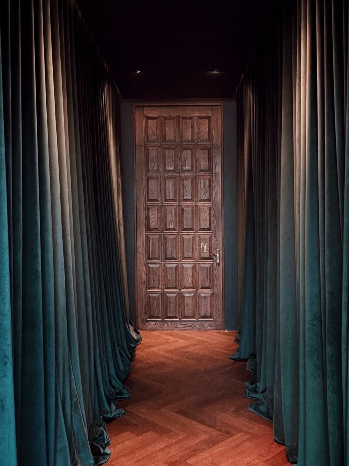 A renovated corridor featuring a wooden door and elegant curtains, showcasing the Phill collection's aesthetic appeal.