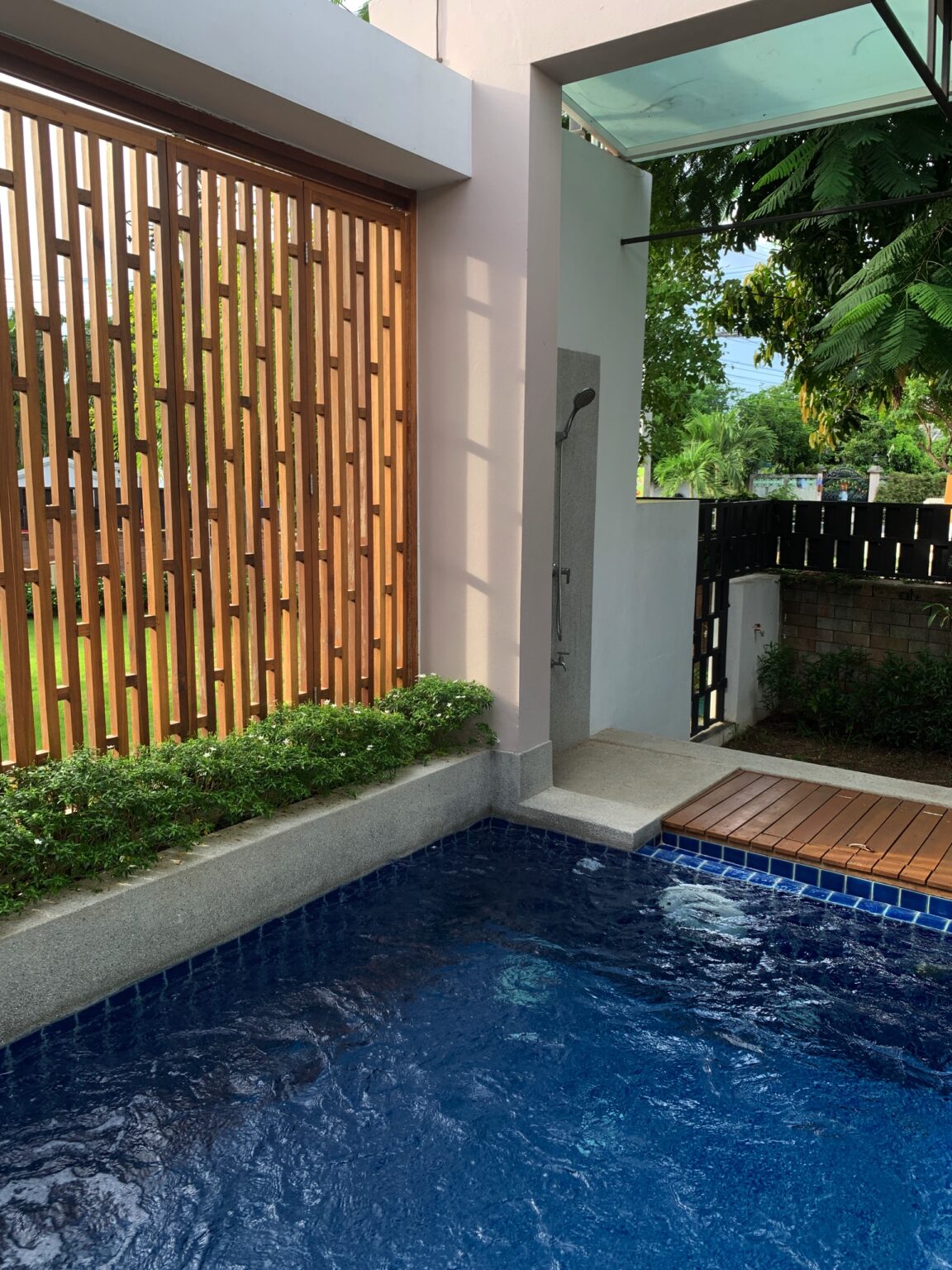 The tranquil swimming pool at Villa Eden Thai, enclosed by a wooden fence and deck, perfect for a peaceful retreat