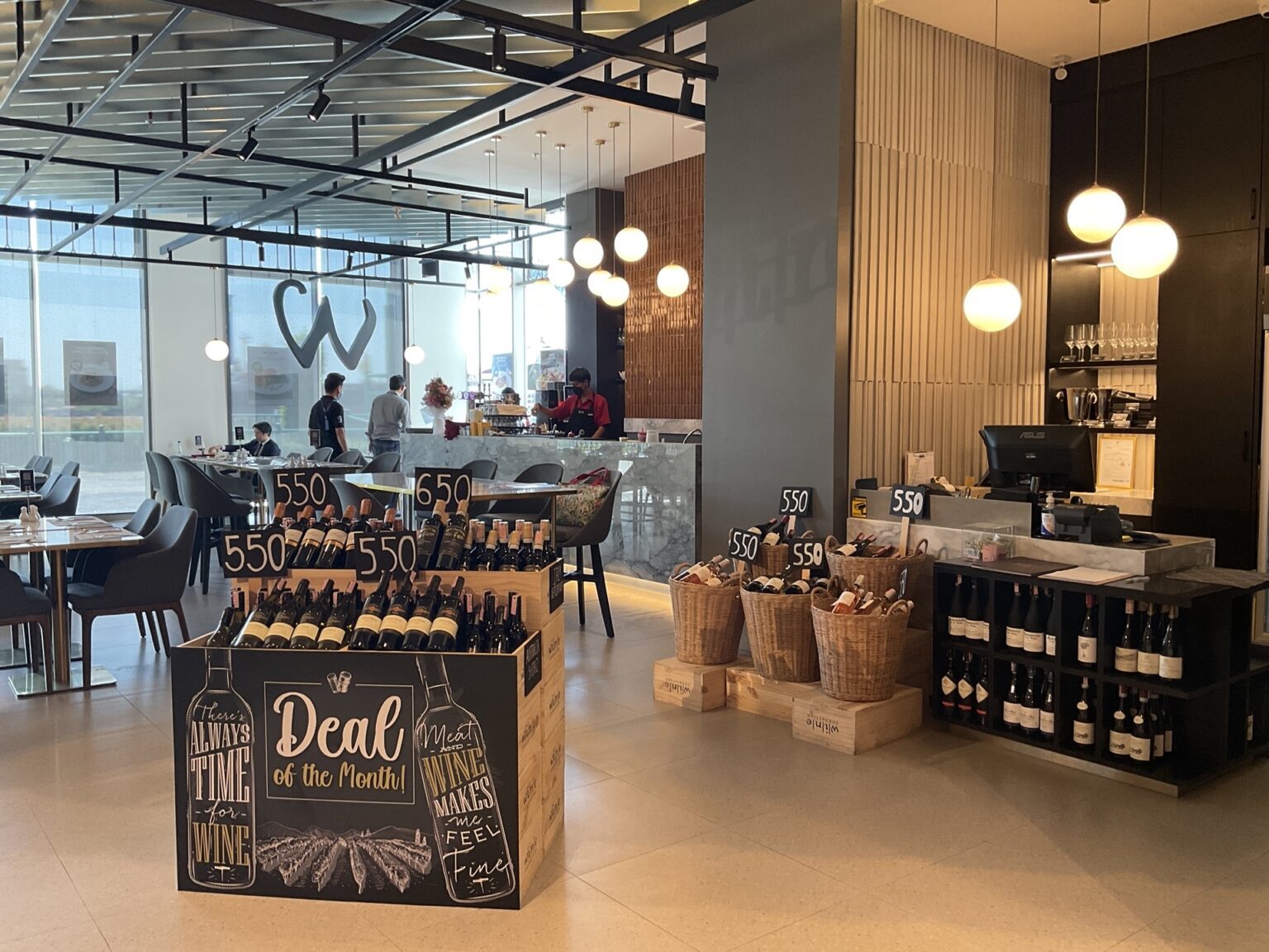 A renovated 'Wine Connection' restaurant featuring a chalkboard menu and an elegant display of wine bottles in the showroom.