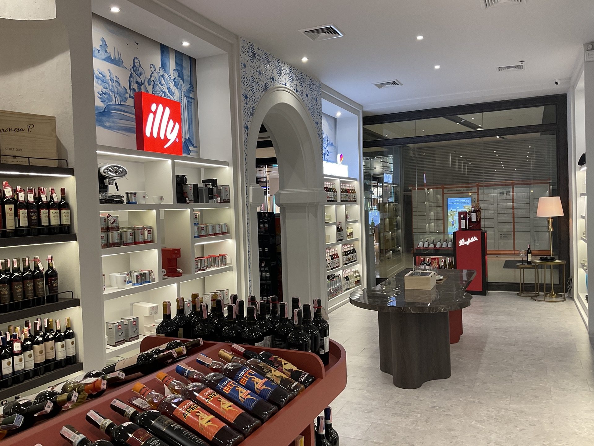 A renovated white 'illy' wine cellar featuring shelves filled with an array of wine bottles