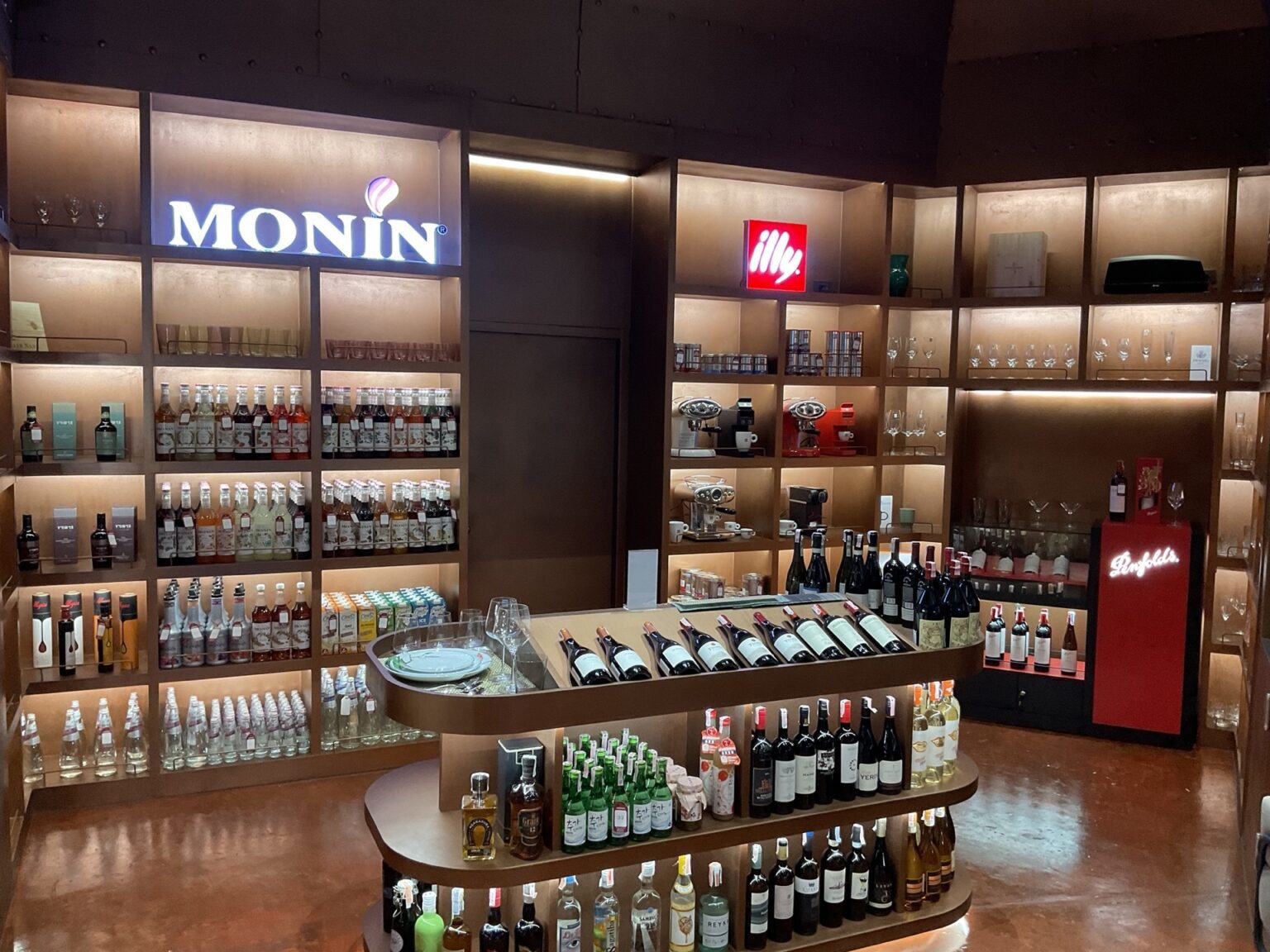 A renovated 'illy' wine shop featuring shelves stocked with a variety of liquor bottles and wine selections