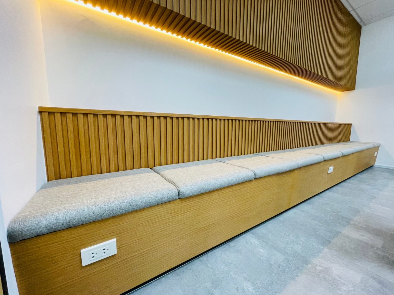 A renovated carpentry office featuring a long wooden bench against a wall and ceiling, showcasing craftsmanship and design