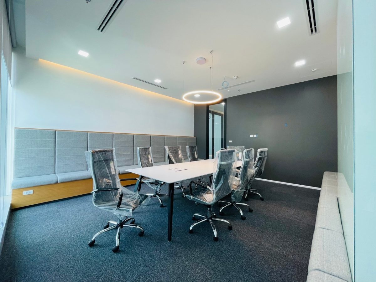 A conference room featuring a large window and a white table, designed for a carpentry renovation office.