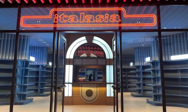 A modernized Italian wine showroom showcasing a bright neon sign labeled "italiana," attracting wine enthusiasts.