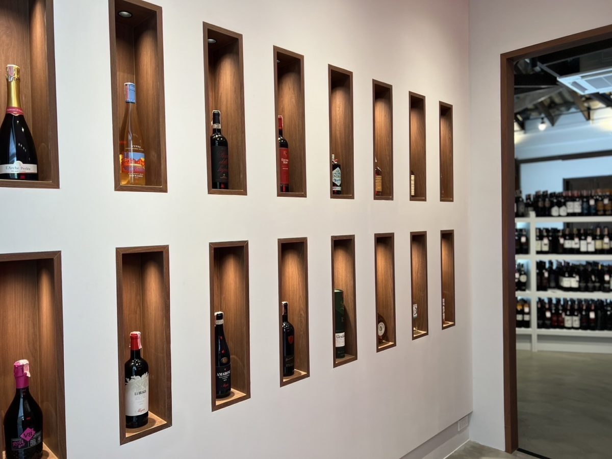 A renovated Italian wine showroom featuring shelves brimming with an extensive selection of wine bottles.