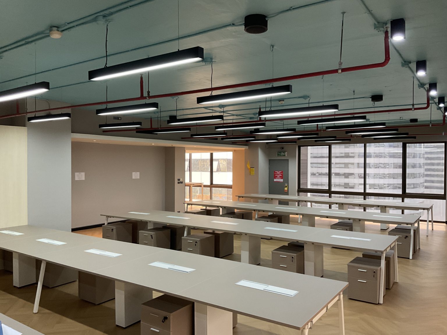 A renovated empty office featuring modern desks and tables, showcasing a clean and organized workspace.