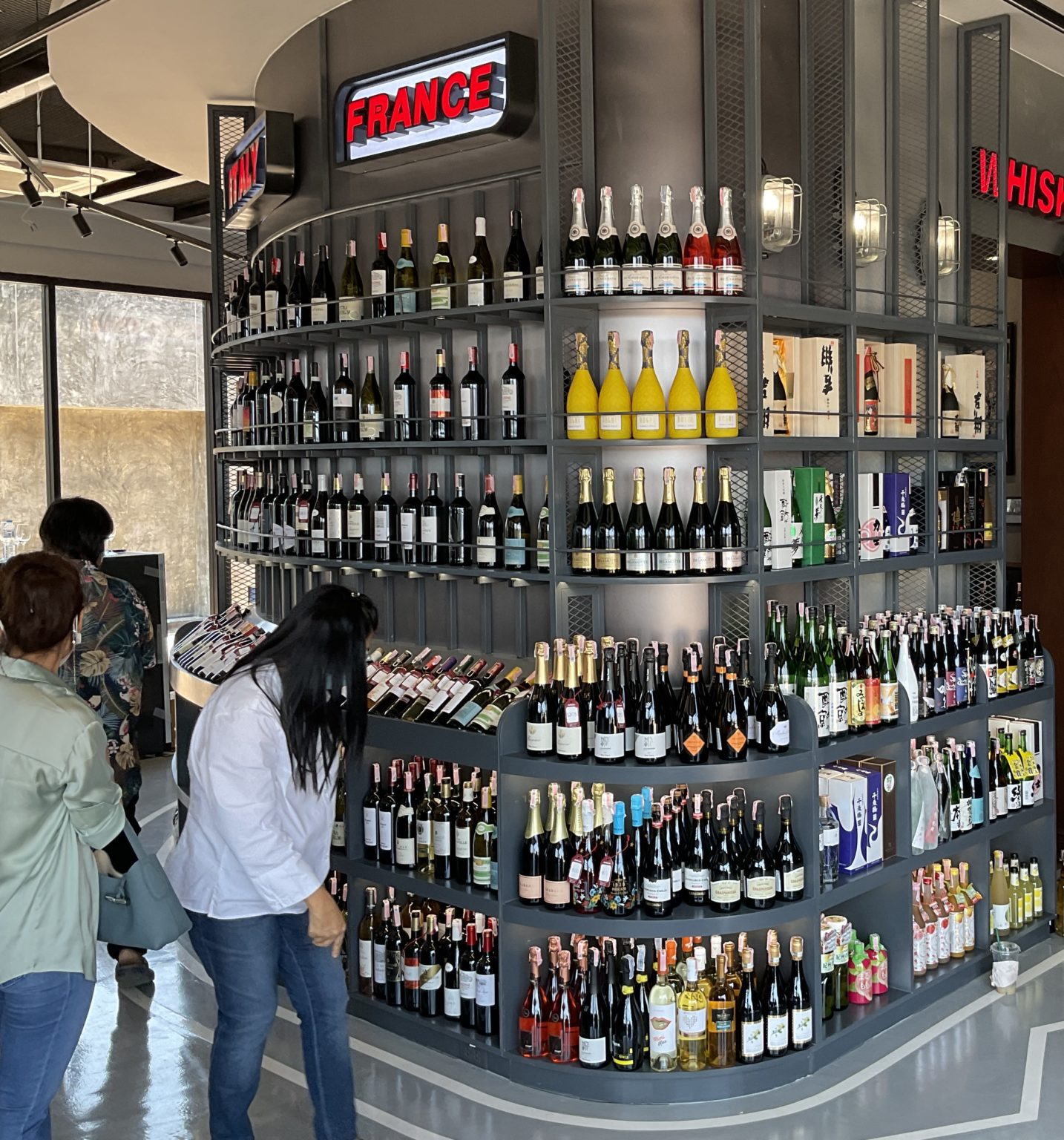 A renovated Italian wine showroom featuring a vast selection of wines displayed elegantly on shelves.