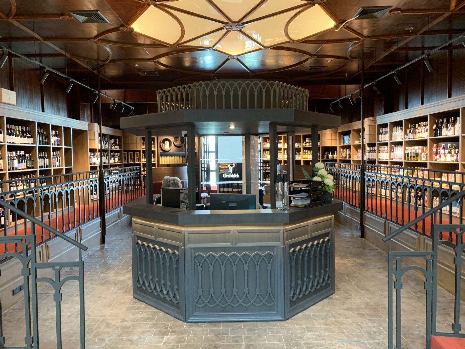 Interior of a renovated Italian wine showroom featuring shelves filled with wine bottles and a stylish counter.