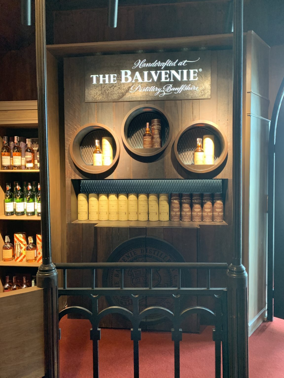 A renovated Italian wine showroom featuring a display case filled with various bottles of liquor, showcasing elegant design