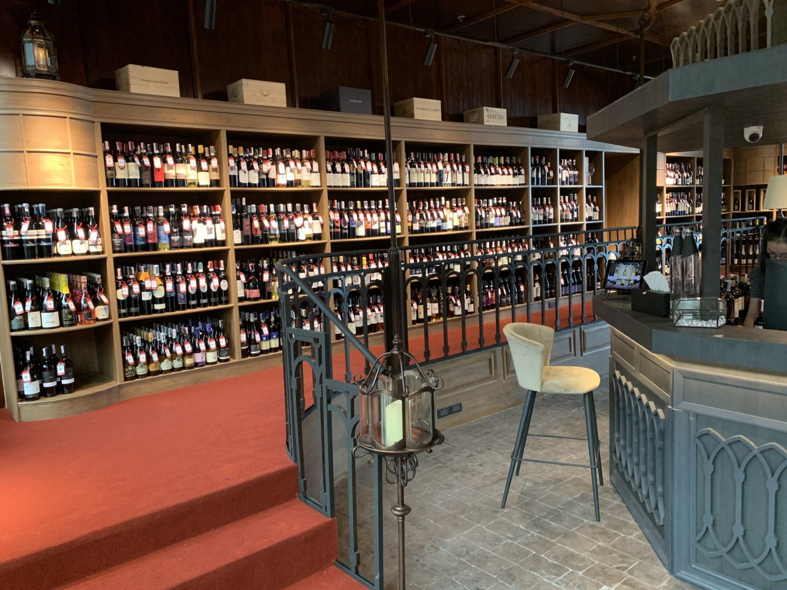 A renovated Italian wine showroom featuring a stylish bar, showcasing an array of fine wines in an elegant setting.