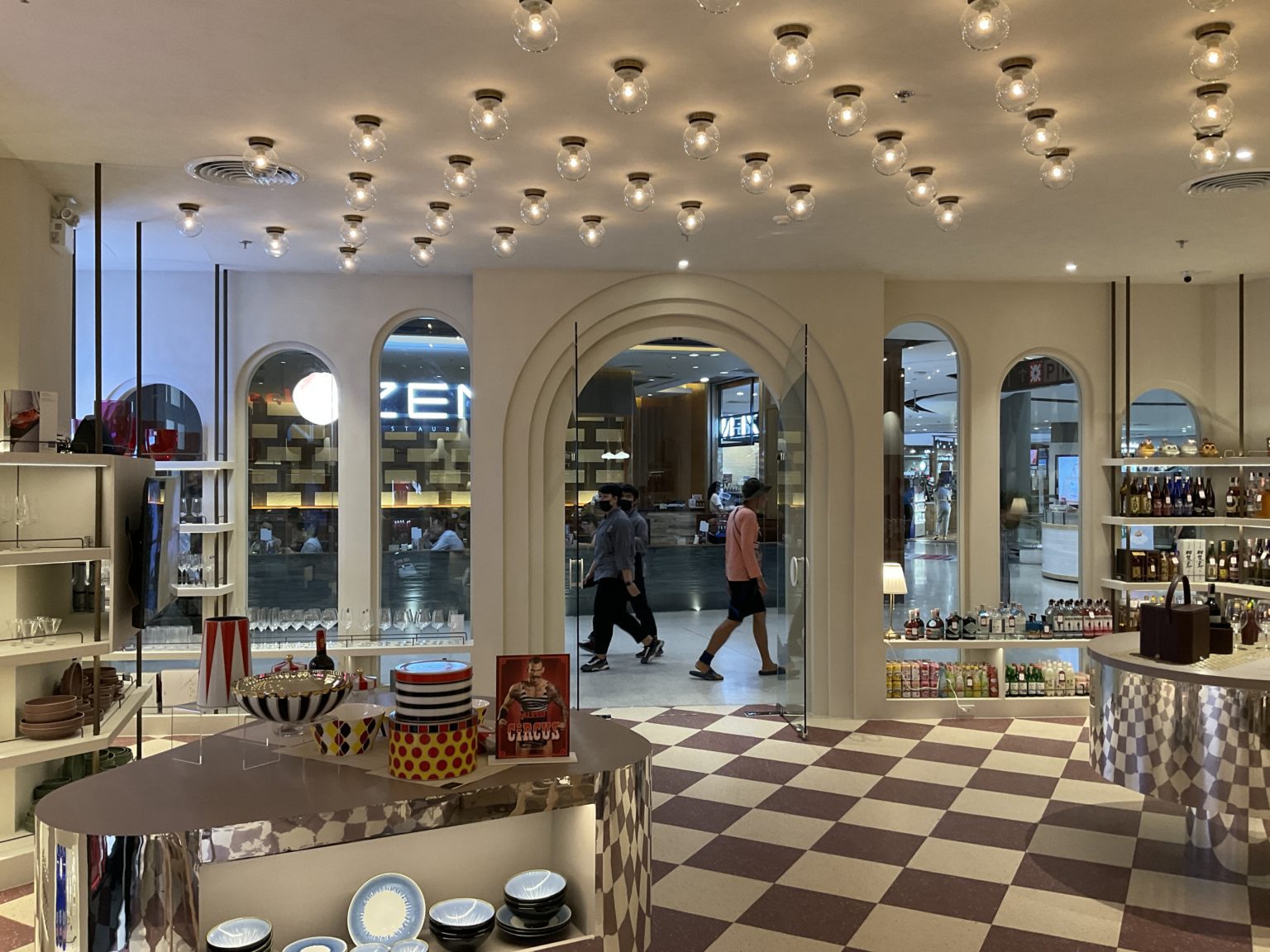 A renovated Italian wine showroom featuring a checkered floor and a prominent display case showcasing various wines.