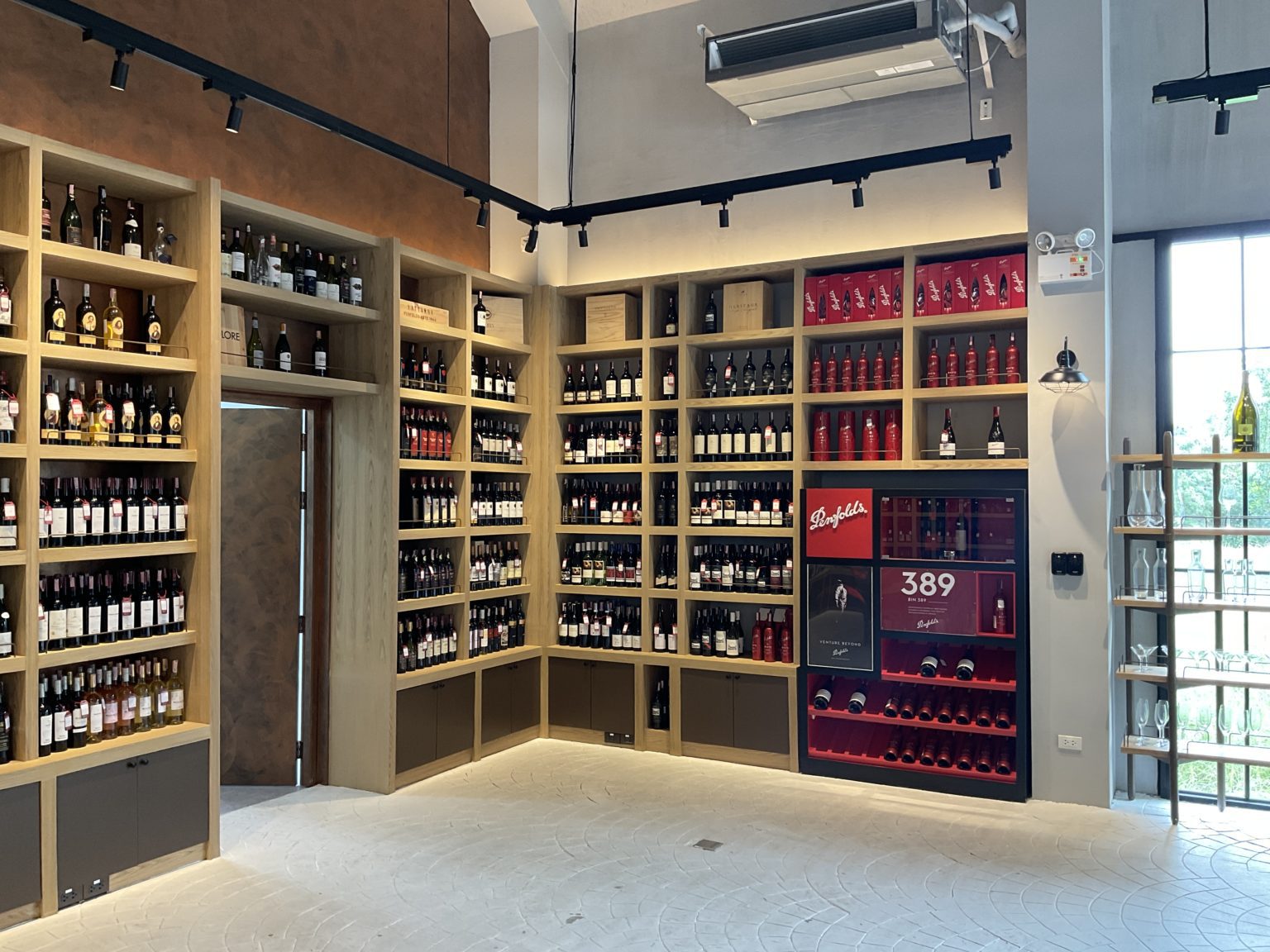 A renovated Italian wine showroom featuring shelves brimming with an extensive selection of wine bottles.