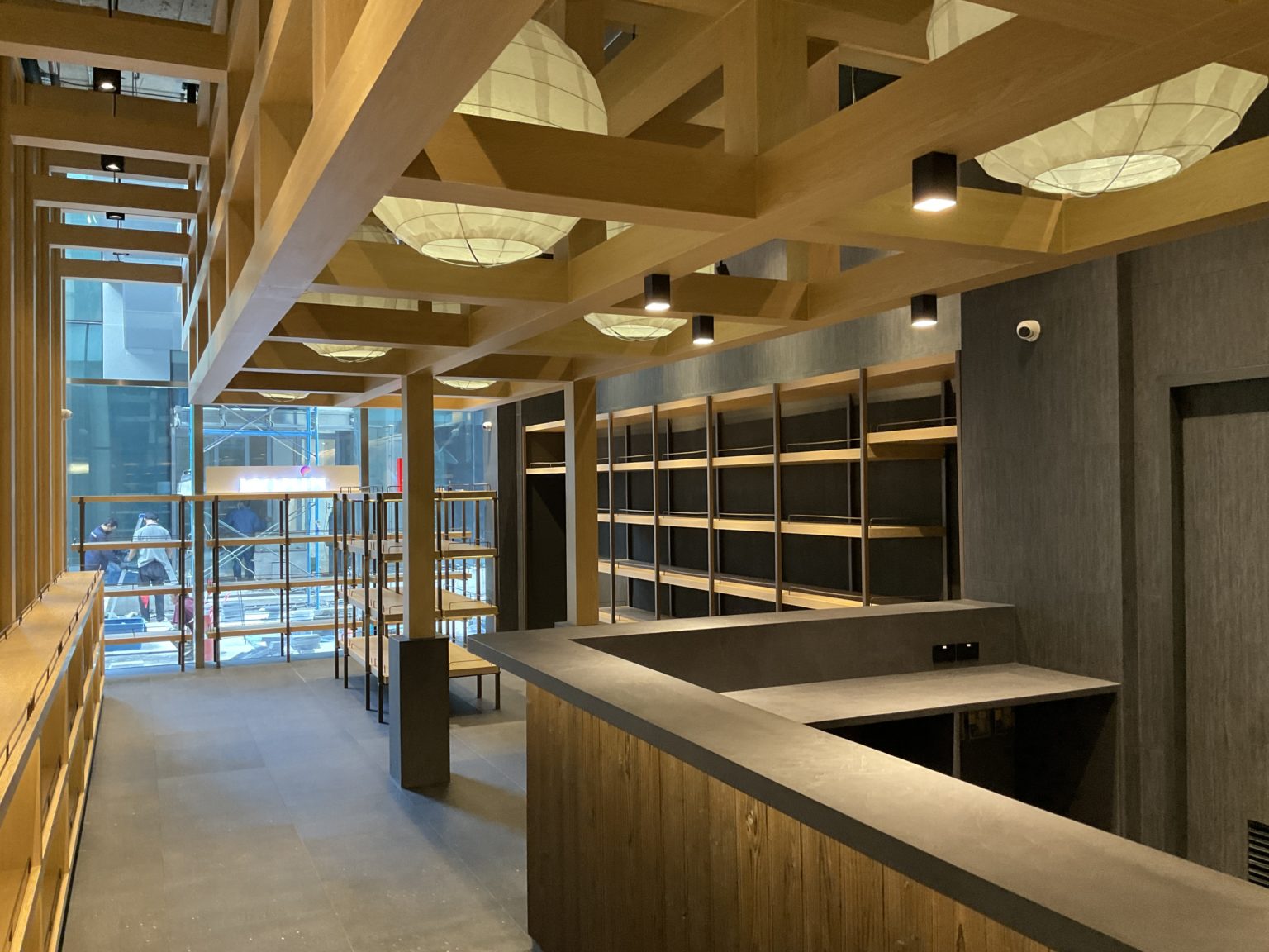 Interior of a renovated Italian wine showroom, showcasing a long hallway with wooden shelves and ambient lighting.