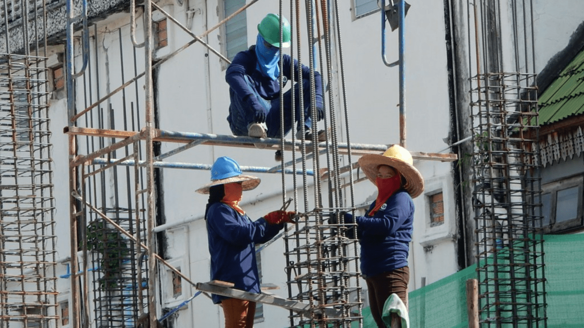 Thai workers on a construction site on scaffolding