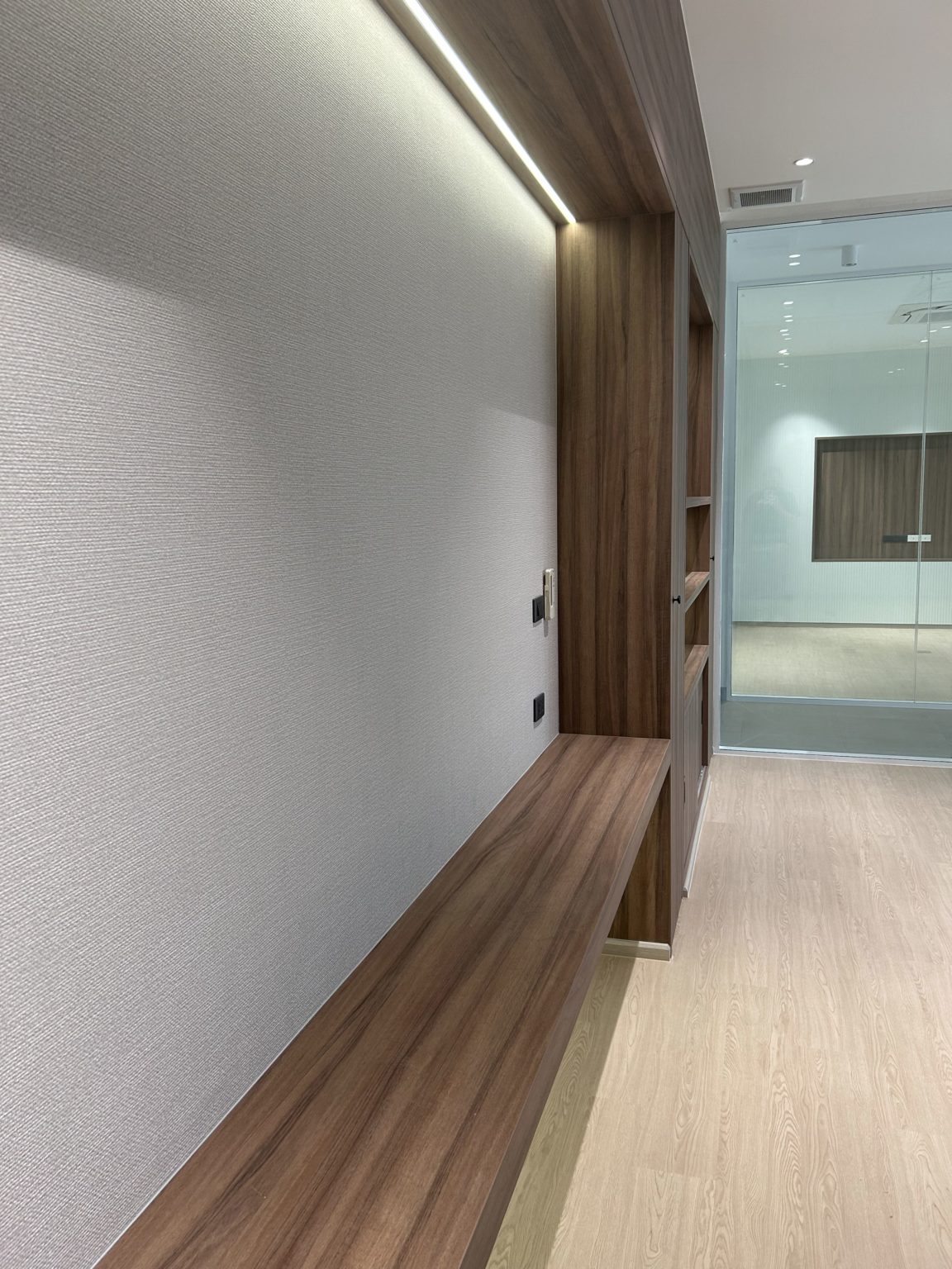 Contemporary office matching wooden shelves and white wall.