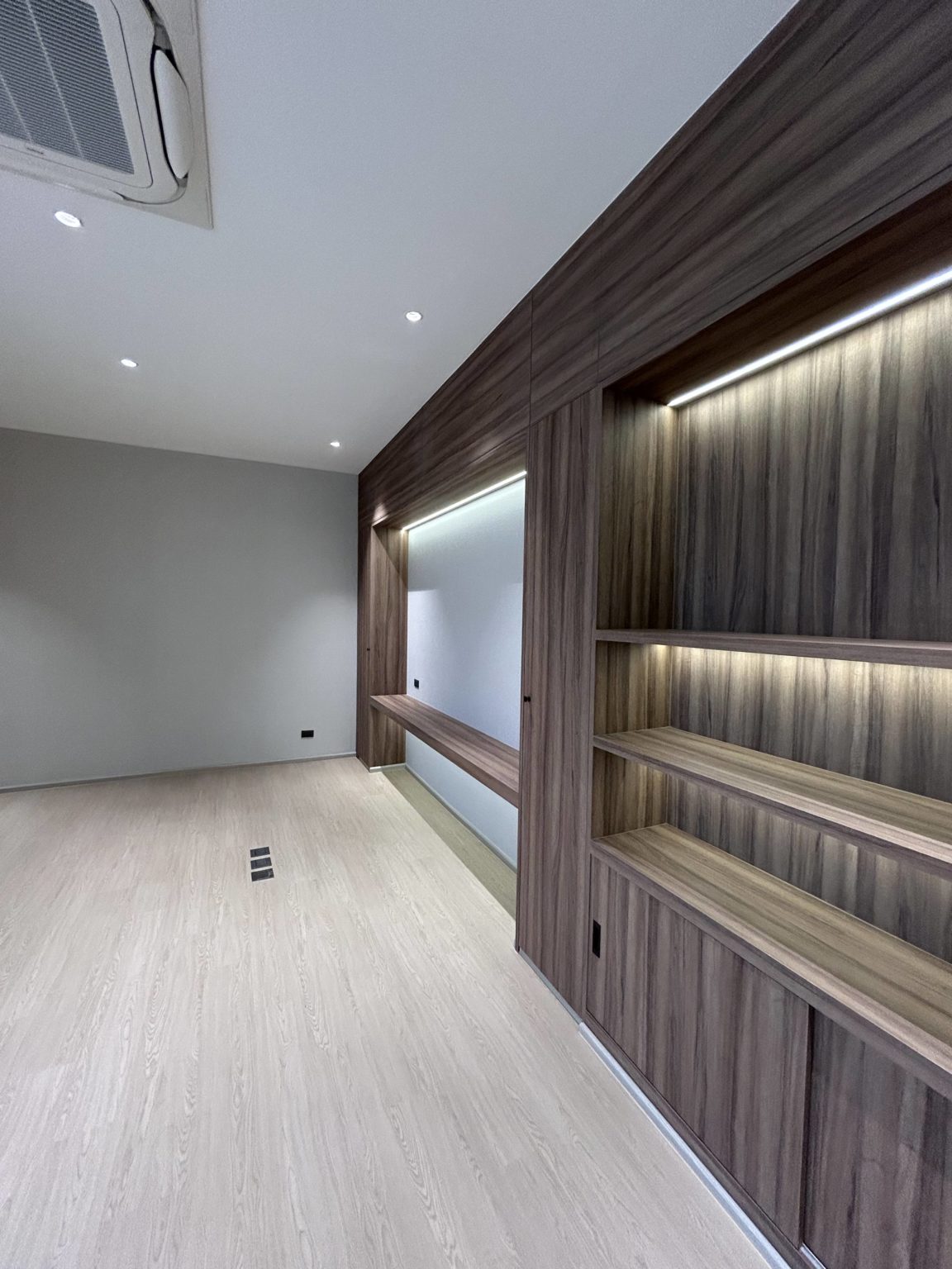 Contemporary office matching wooden shelves, light and white wall.