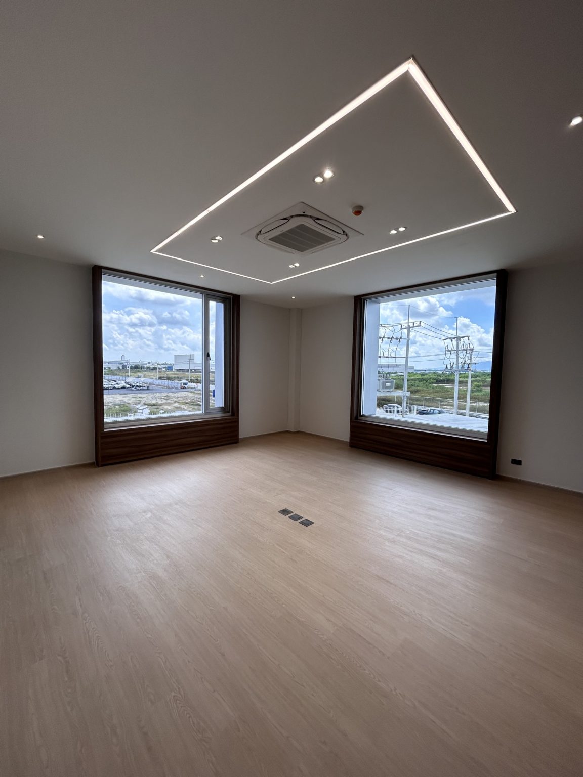 Two large windows with wooden frames in a bright office.