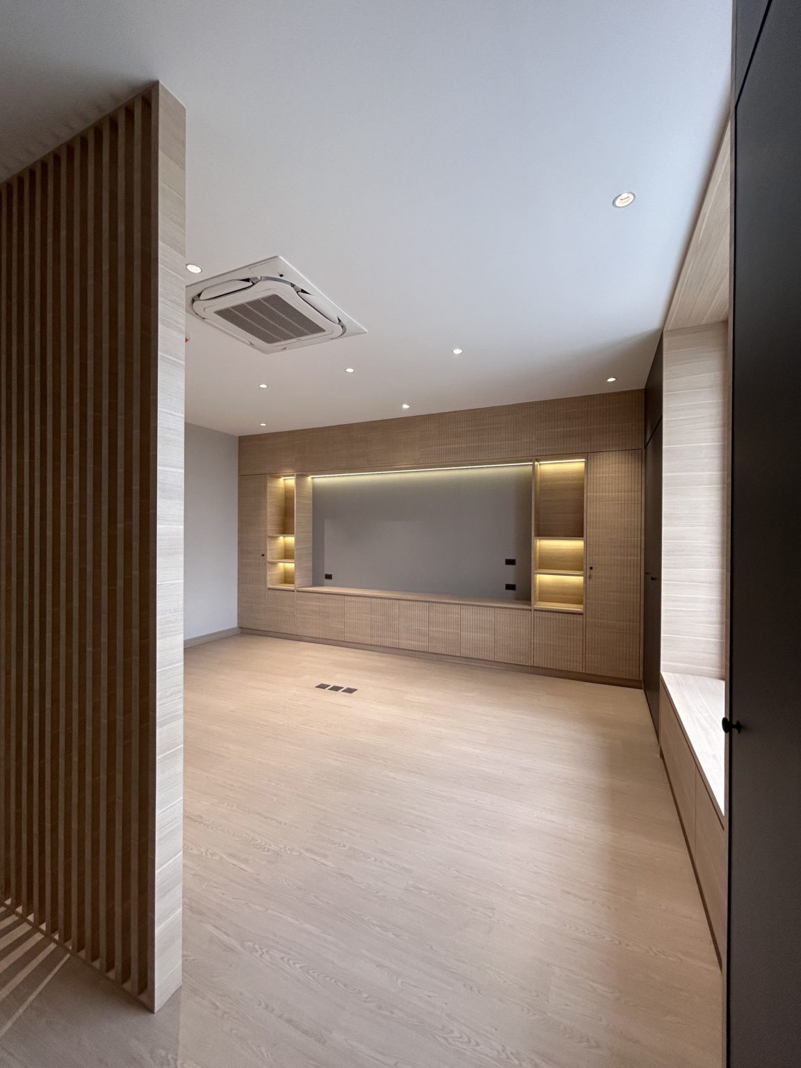 Contemporary office with wooden shelves and wall matching with white wall.