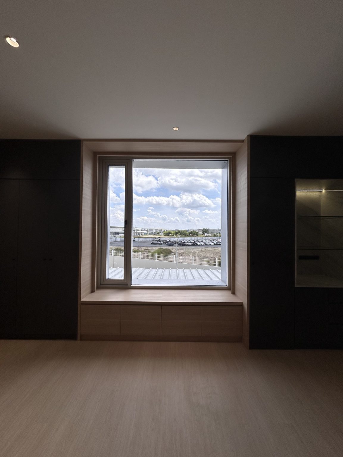 Office with one large bright windows featured with dark wooden framework.