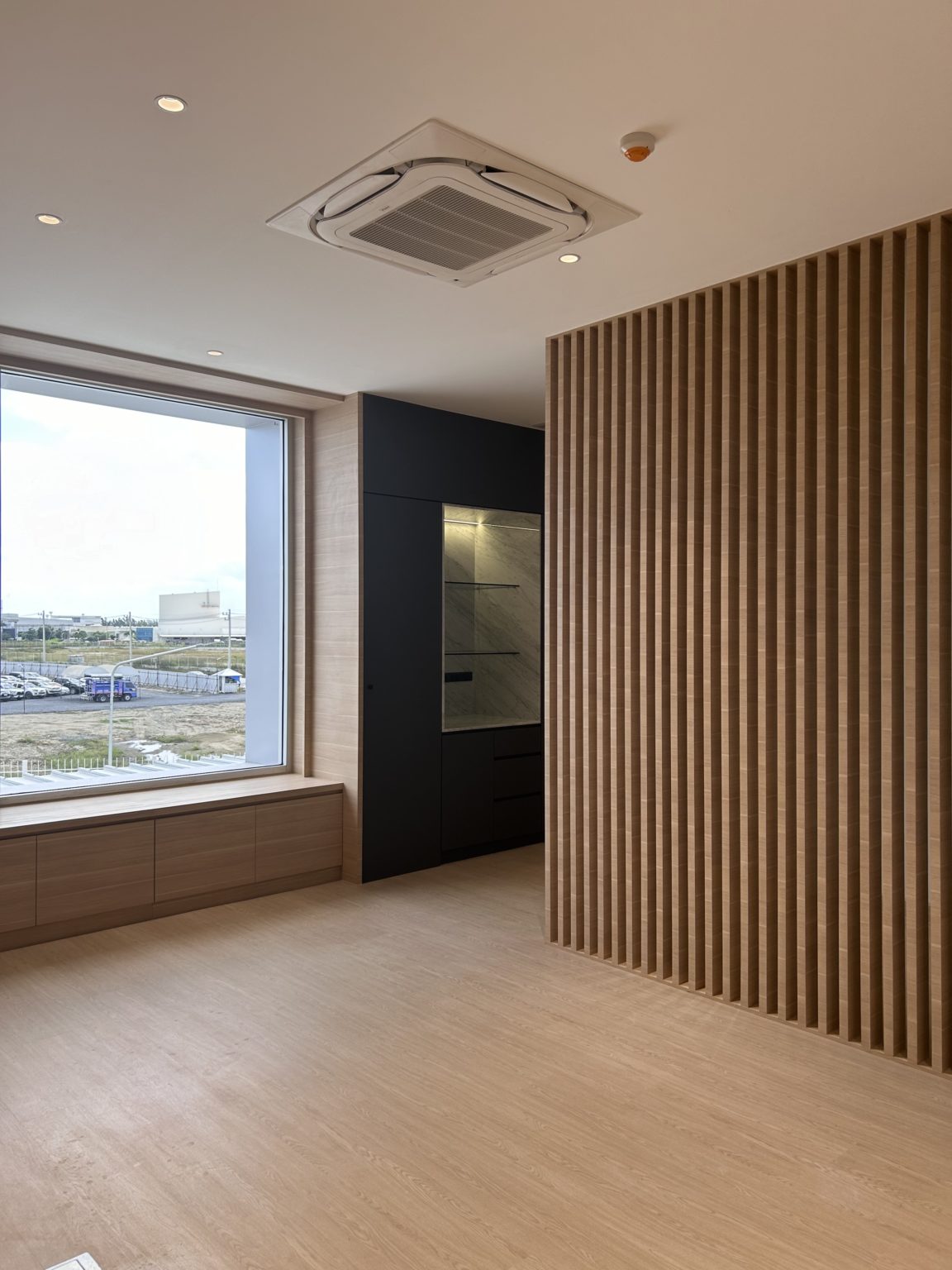 Modern office with brown and dark wooden wall featured with large windows.