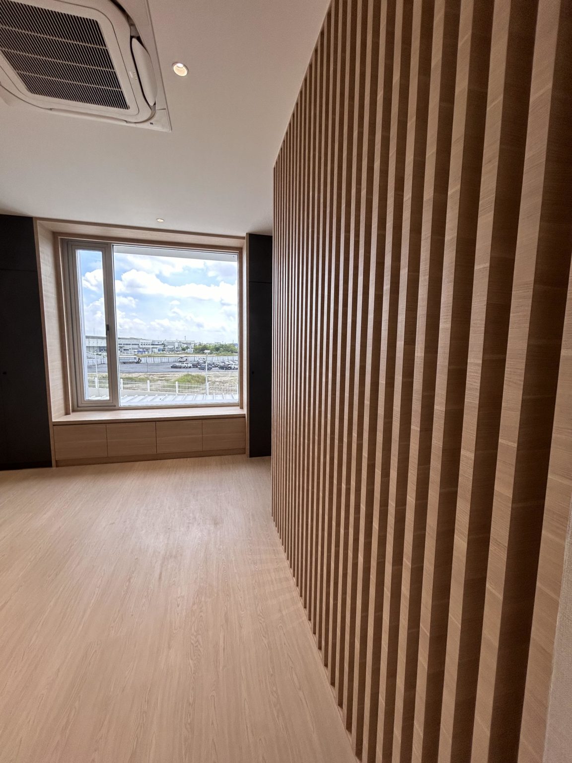 Modern office with brown wooden wall featured with large windows.