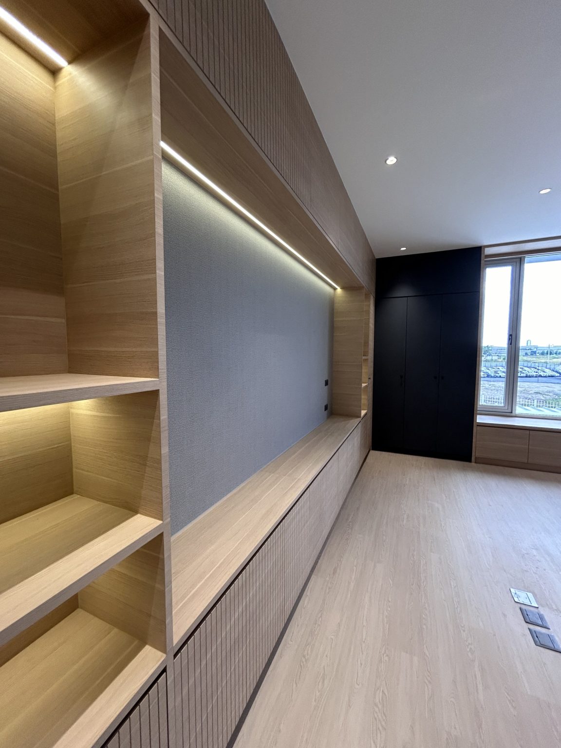 Modern office with wooden shelves and bright light.