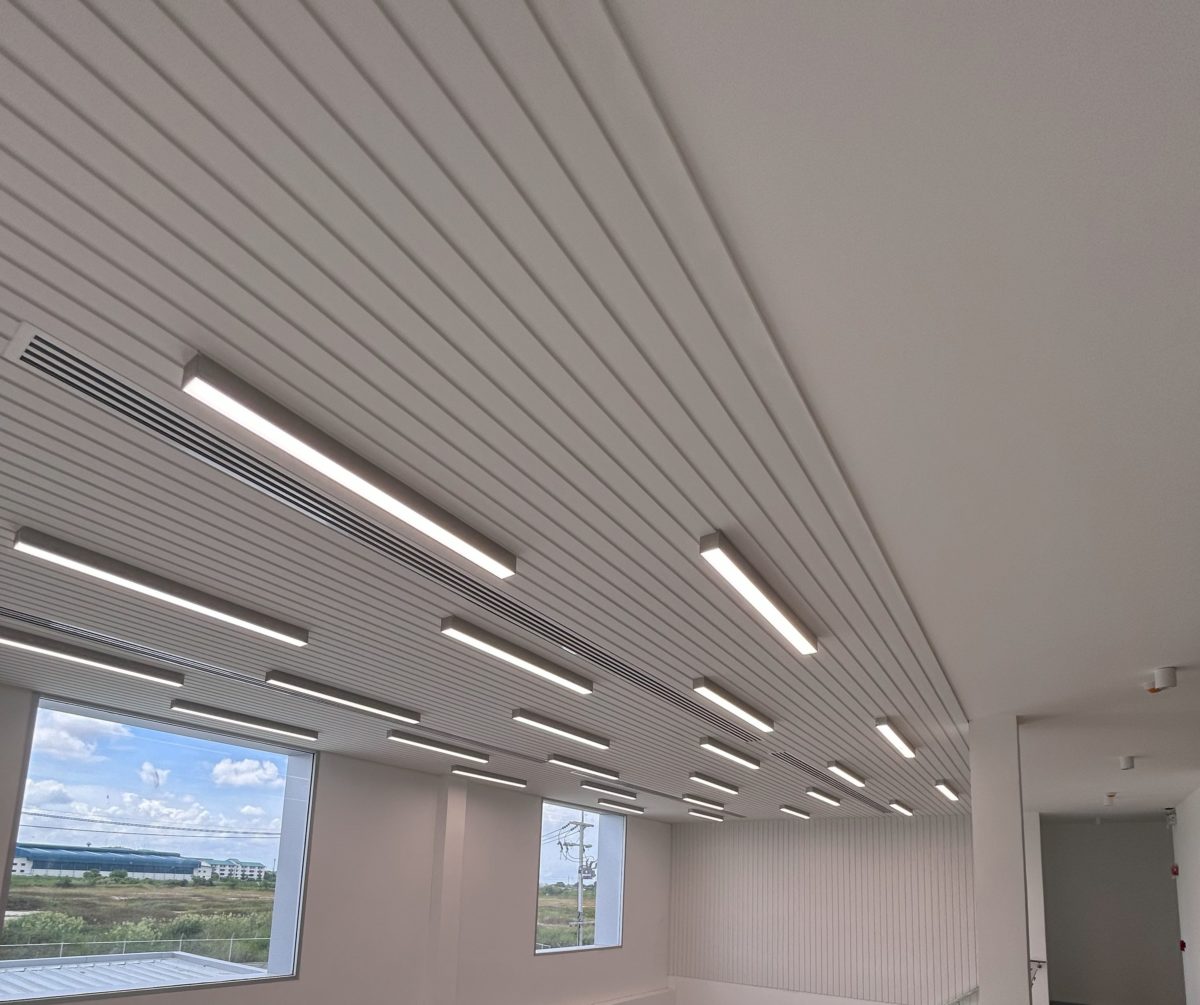 White wooden ceiling with large integrated lights, with large windows.