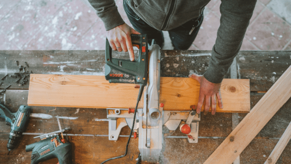 Carpenter cuts a board in two.