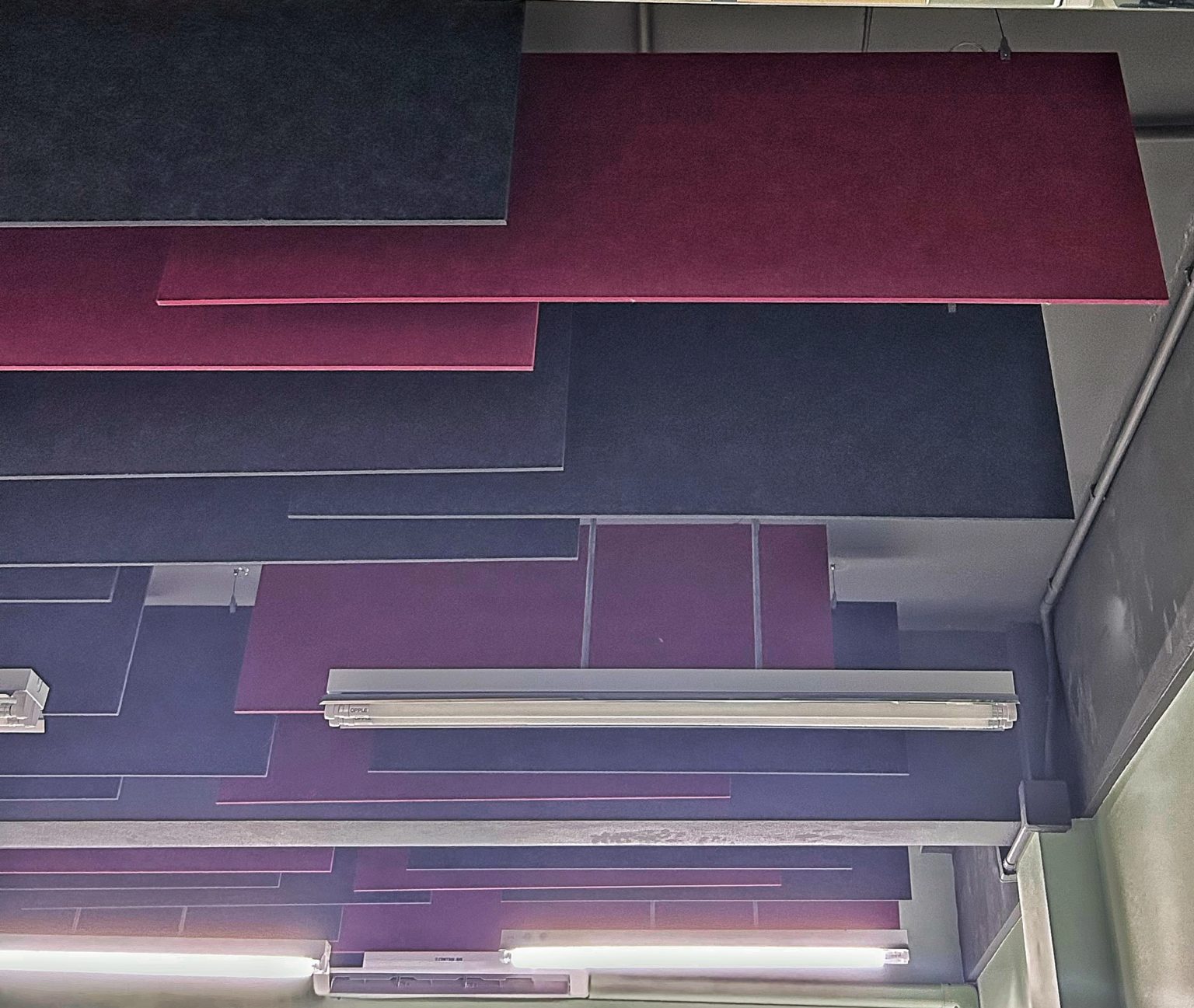 Red & black suspended acoustic panels installed by Project'Sabai for office productivity.