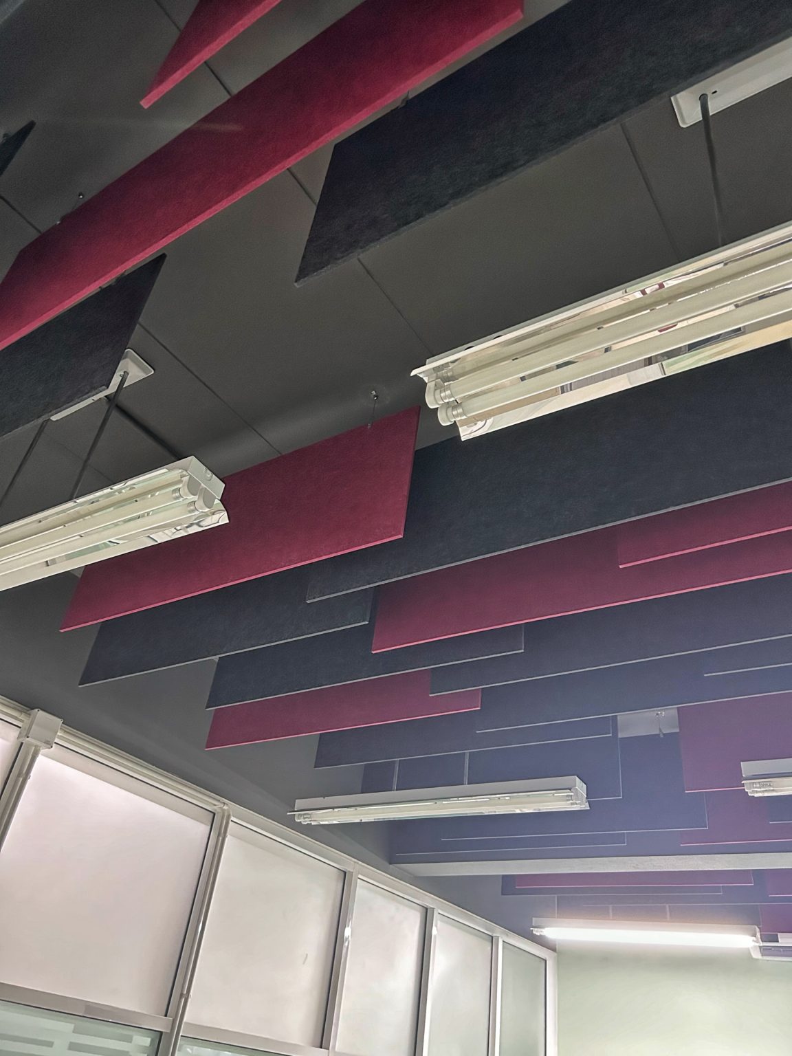 Red & black suspended acoustic panels by Project'Sabai for office comfort.